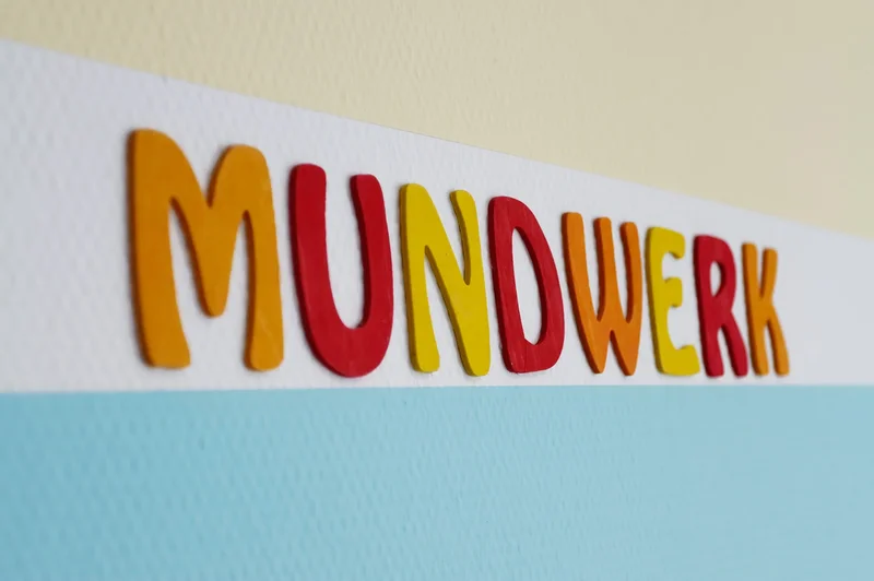 Farbenfroher Mundwerk-Schriftzug an der Praxiswand